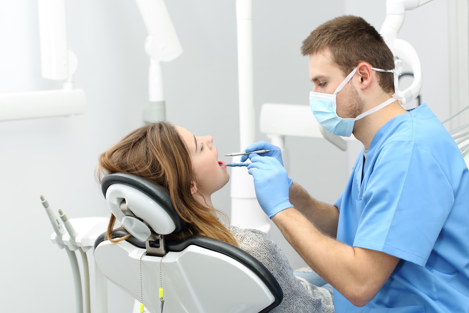Стоматолог лечит пациента